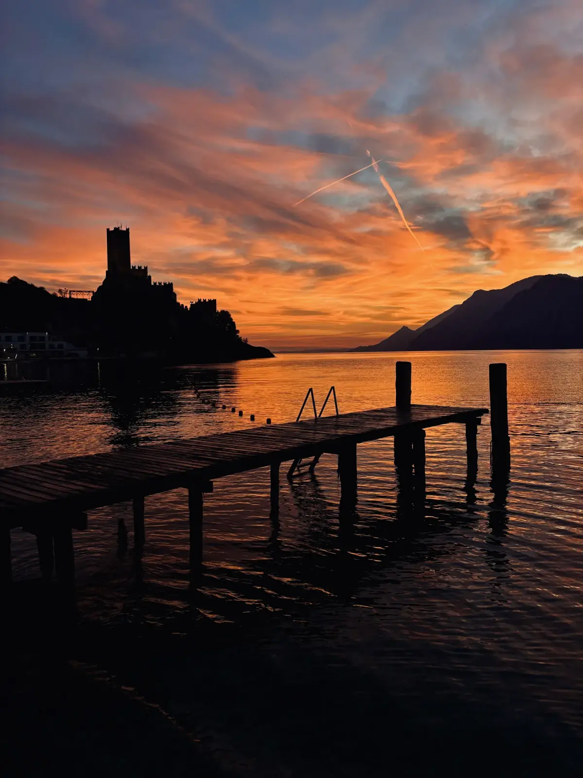 Pontile del Lido Paina al tramonto con il Castello Scaligero in controluce