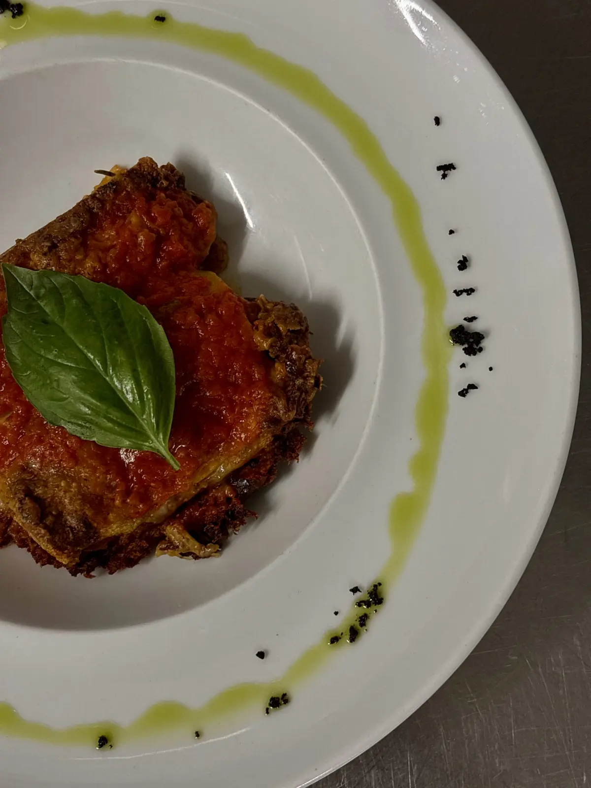 Parmigiana con basilico fresco e olio al basilico
