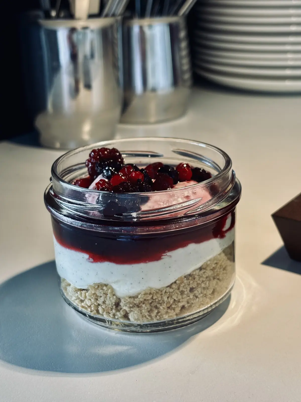 Cheesecake in vasetto con base di biscotto, crema e frutti di bosco