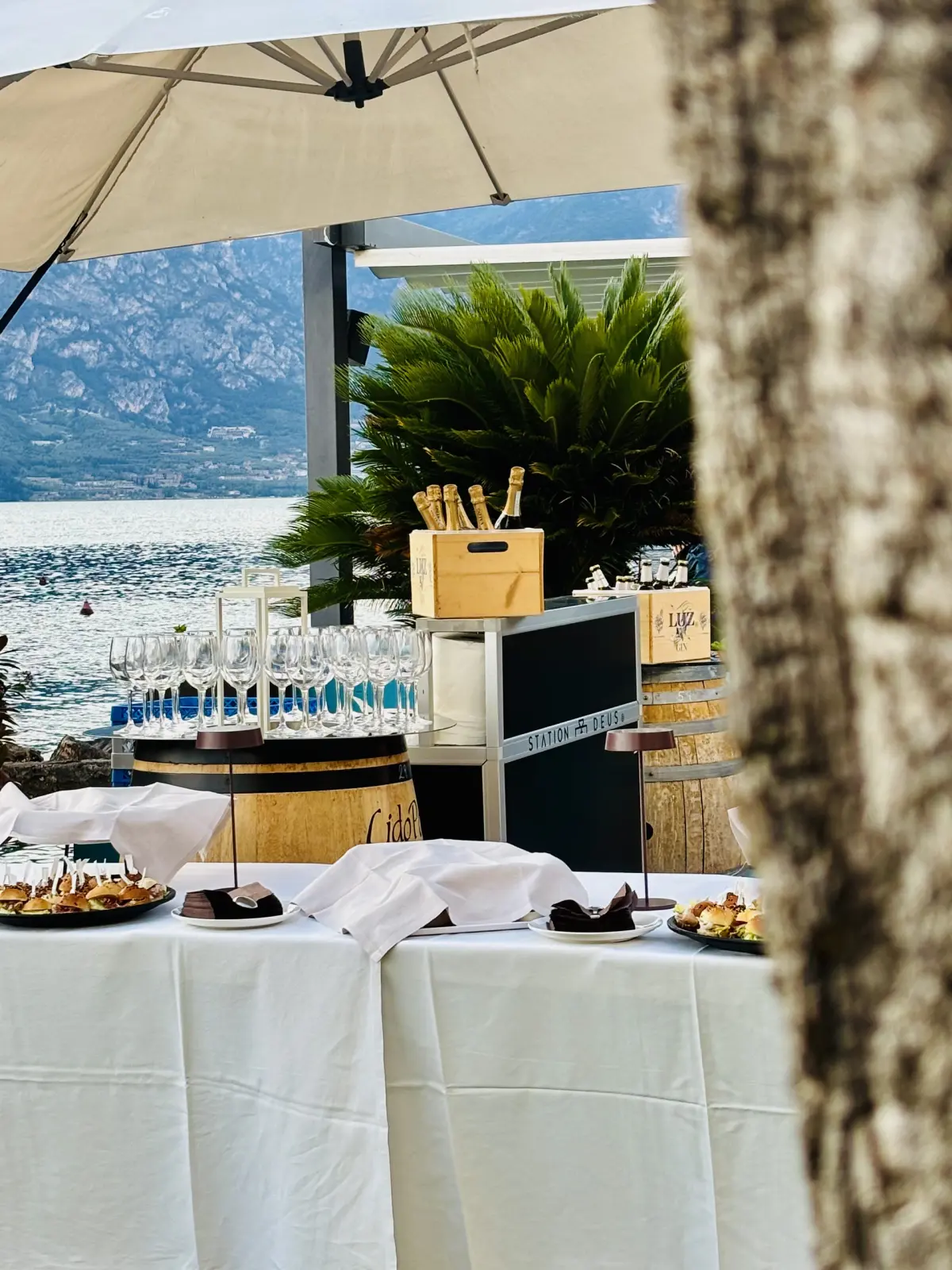Buffet di aperitivo con bollicine in ghiaccio sotto l'ombrellone, in riva al lago